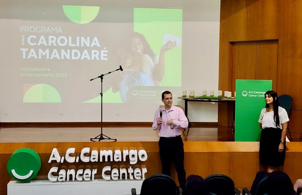Cerimônia do Programa Dona Carolina Tamandaré, com duas pessoas à frente de um auditório.